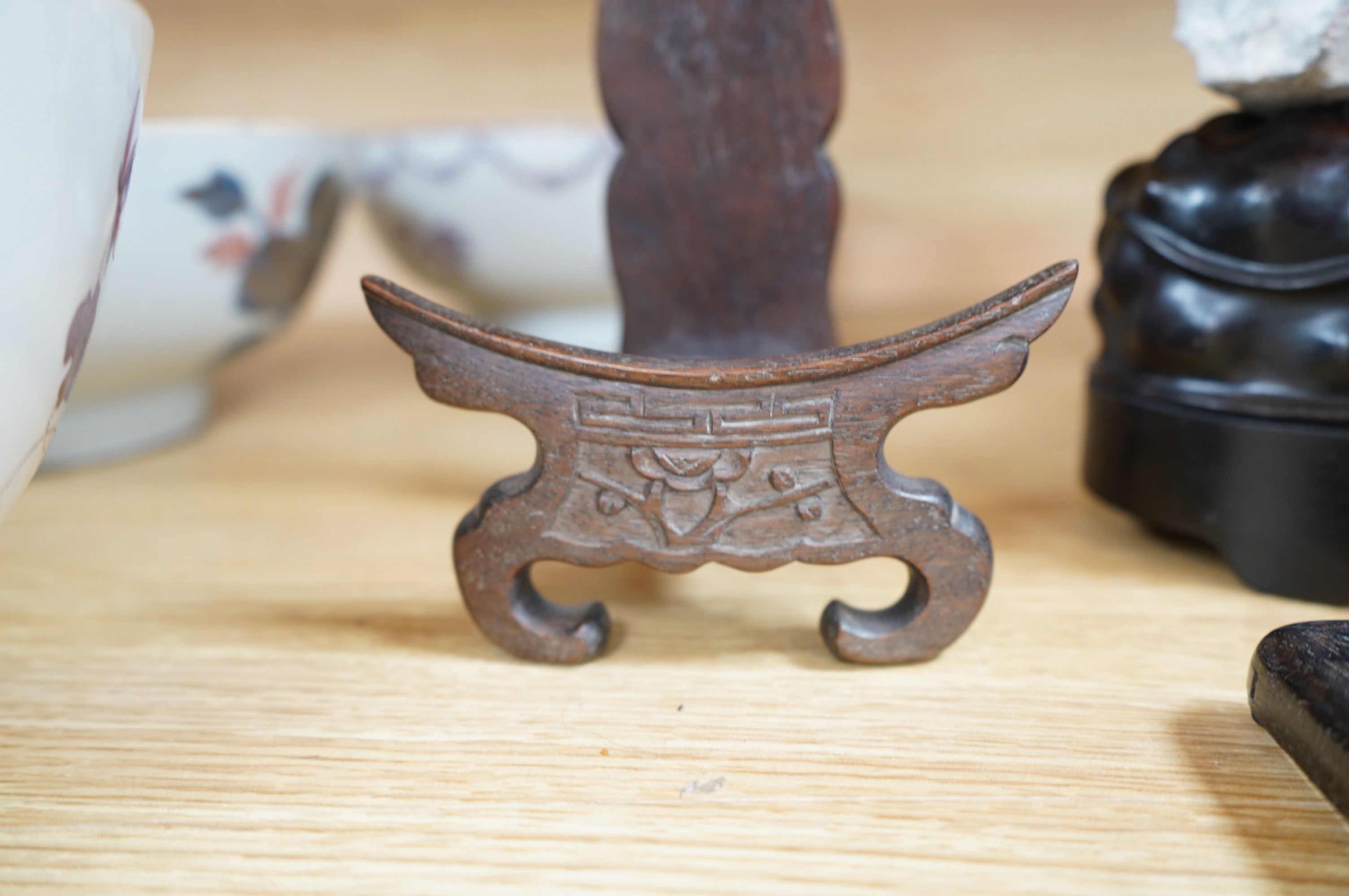 A Chinese grey stone scholar's rock, on stand, together with two Chinese hardwood plate stands and small hardwood frame, largest overall 38cm high. Condition - fair to good